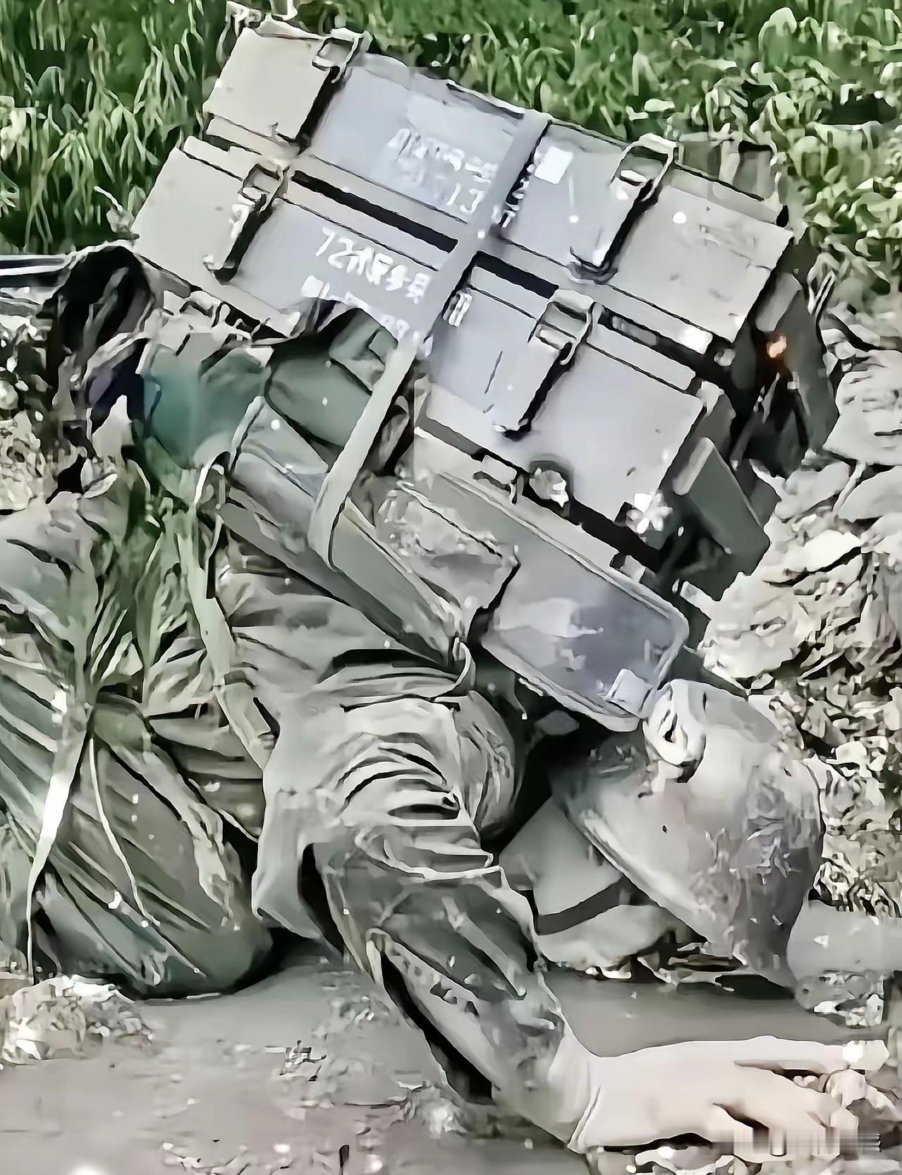这是当年参加自卫反击战战士留下来的一张照片，他身上背负着沉重的箱子，趴在水边喝水