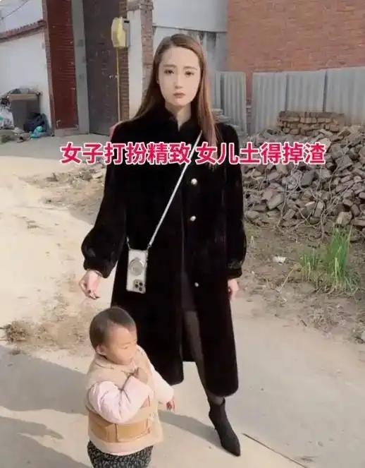 村口的小路上，这一幕被孩子爸爸拍了下来。女人一身精致长款皮草，妆容得体，穿搭时髦
