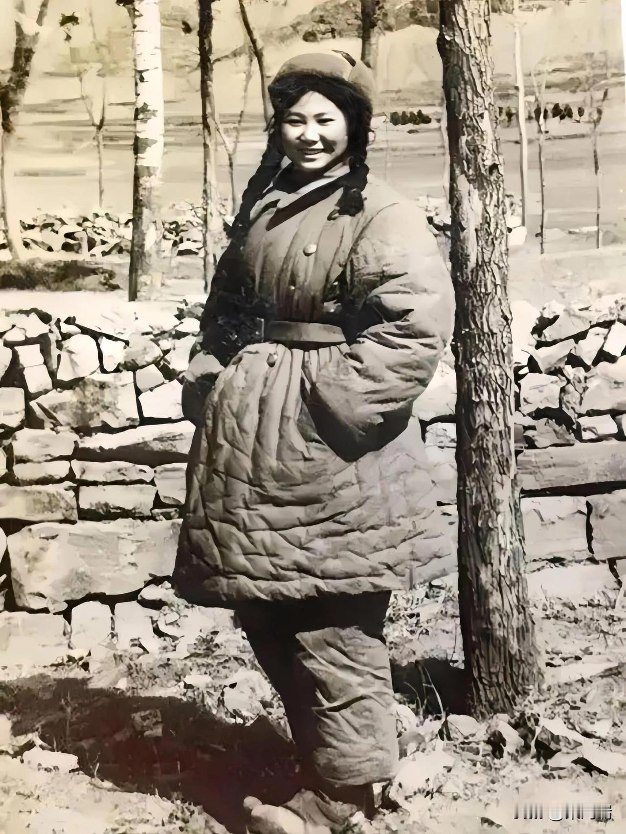 抗美援朝时期，真实的志愿军女战士留影，照片中这位女战士穿着厚重的棉军服，扎着两个