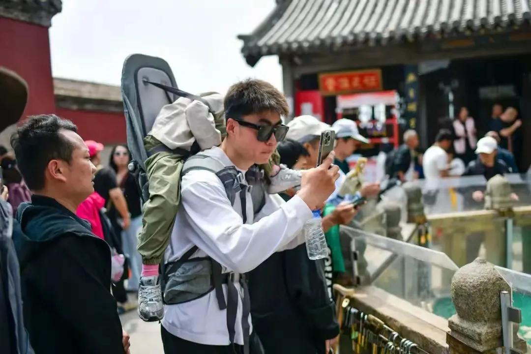 五一假期场景之一：大学生自主创业，泰山陪爬山行业其乐无穷。这位大学生不但陪爬泰山
