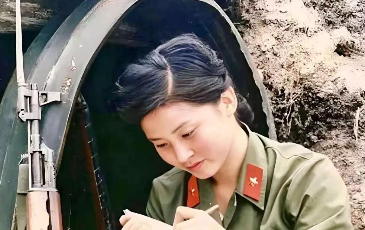 对越自卫反击战中，一个年轻漂亮的女战士，正坐在猫耳洞外，全神贯注地给家人写信。她
