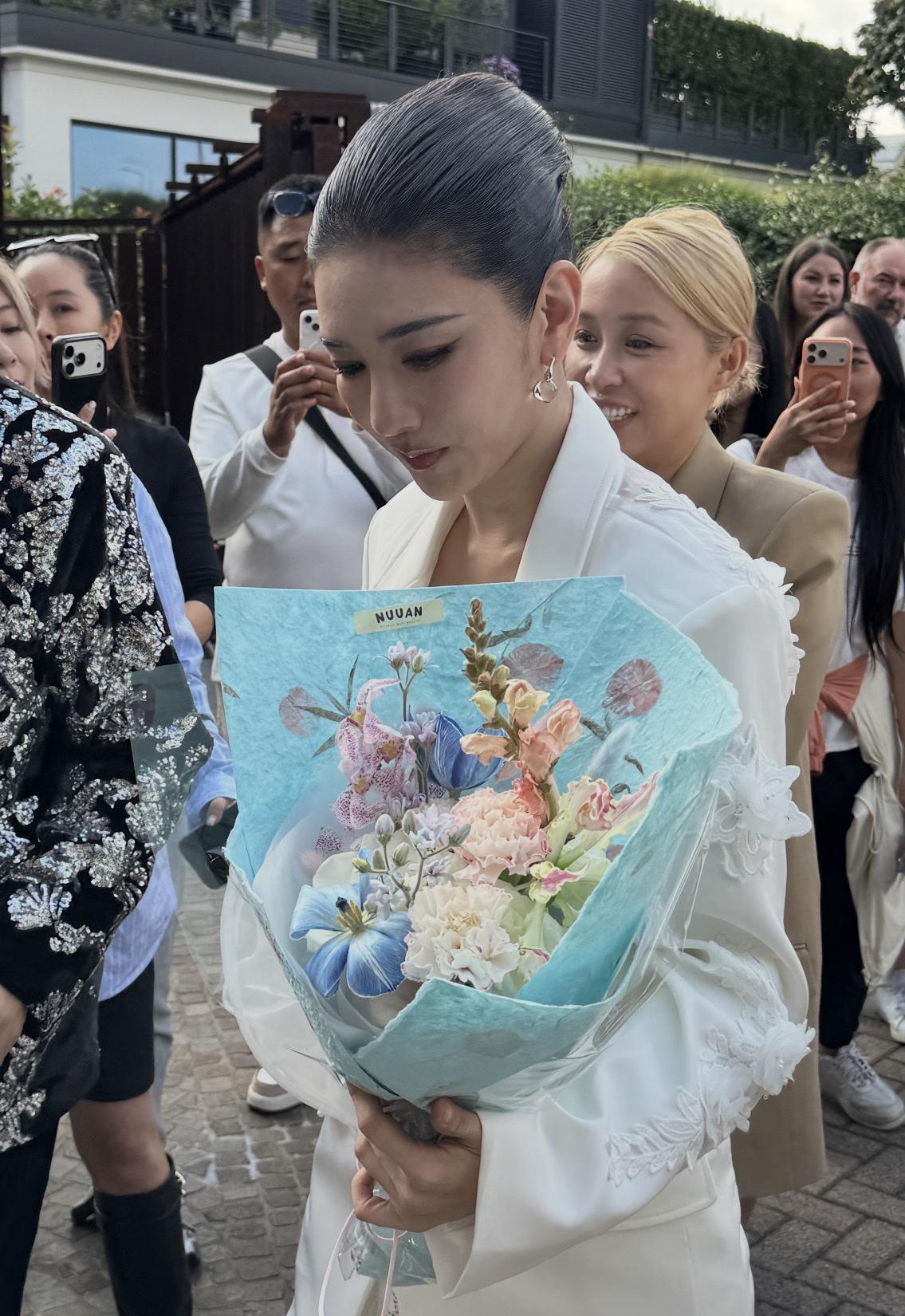 米兰时装周黄奕这身造型挺出圈的，女明星都穿礼服长裙，她白色西装搭配白色花朵，再加