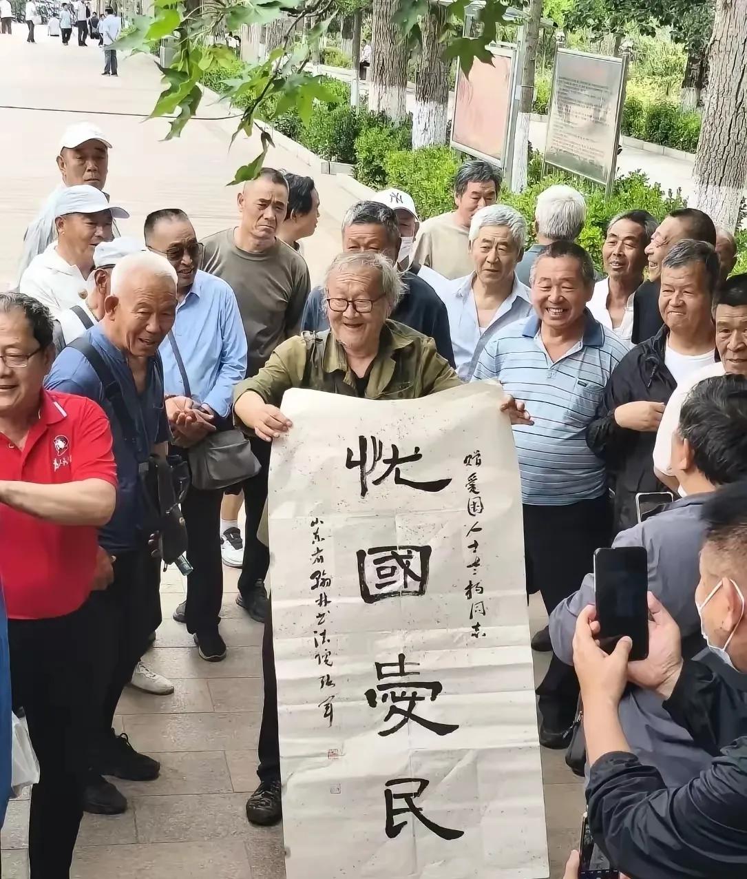 济南英雄山风云人物老杨最近非常高兴，因为某书法家给他了一副“忧国爱民”的书画。