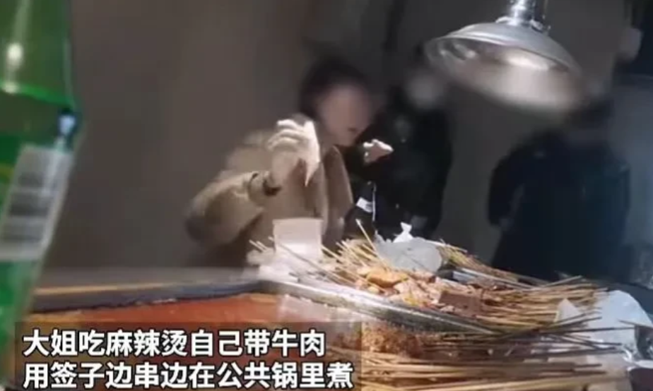 北京，一女子在麻辣烫店用餐，一边将自带牛肉往签子上串，一边往公共锅中放，其行为引