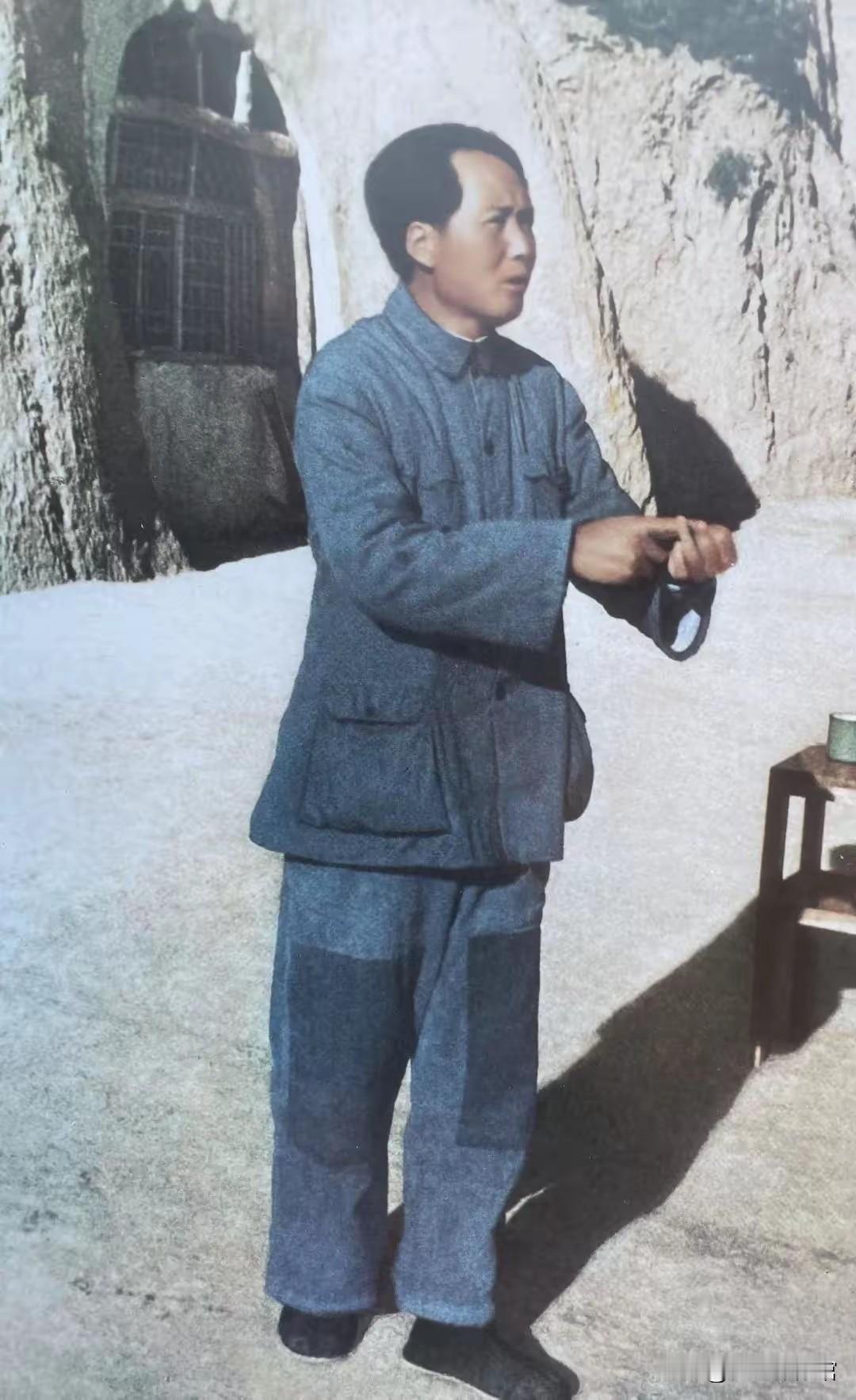 这张照片拍摄于延安抗战时期。黄土窑洞古朴简陋，毛主席身着打有补丁的粗布军装，正在