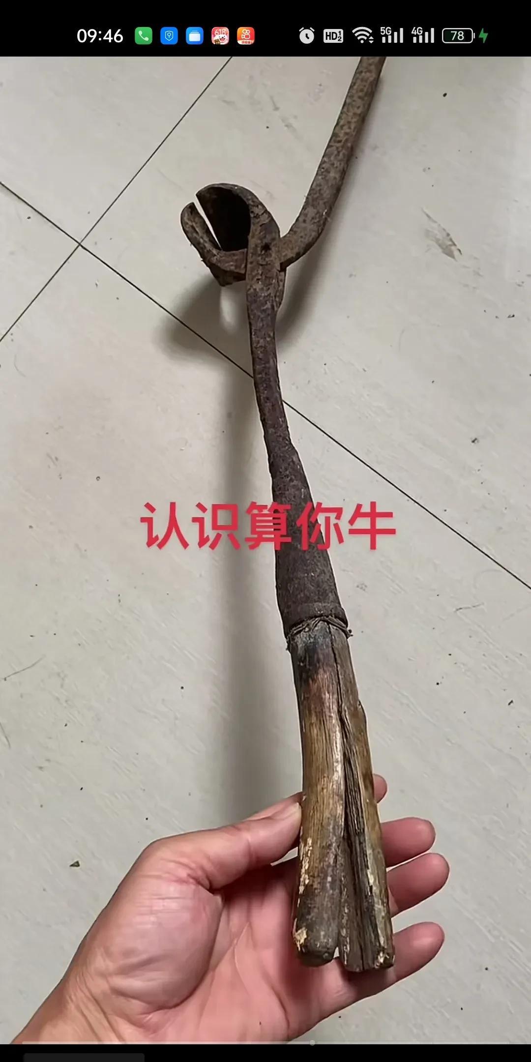 这根看似平平无奇，却又透着股陈旧沧桑感的物件，一头是开裂的木柄，一头是弯曲生锈的