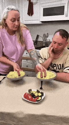 国外的一对夫妇在家中吃晚餐，老婆制作好的面条端上来饭桌，老婆把2个火腿的面条放到