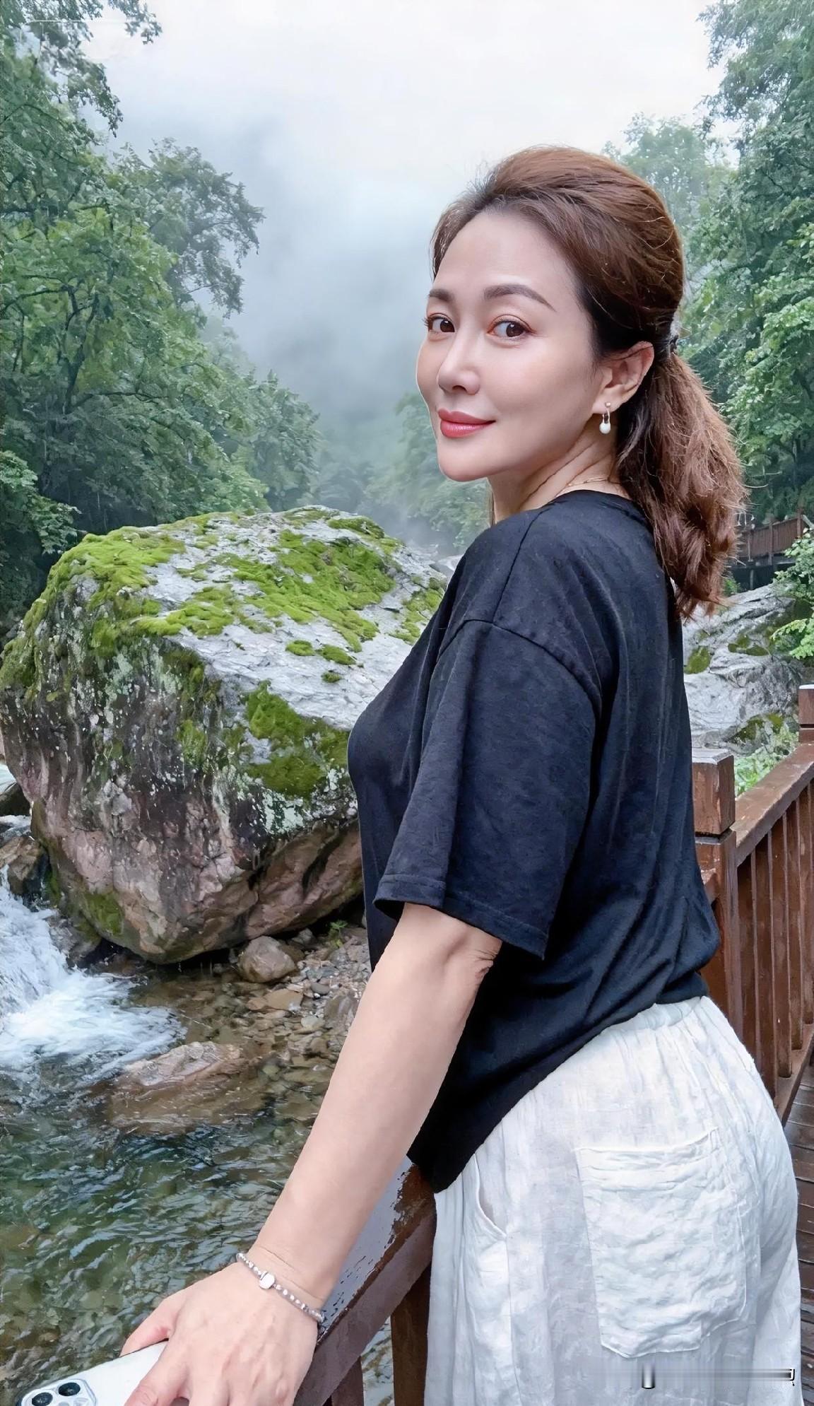 溪水潺潺，苔石含烟，素衣淡妆，与山色雾气相映，静享自然清欢。