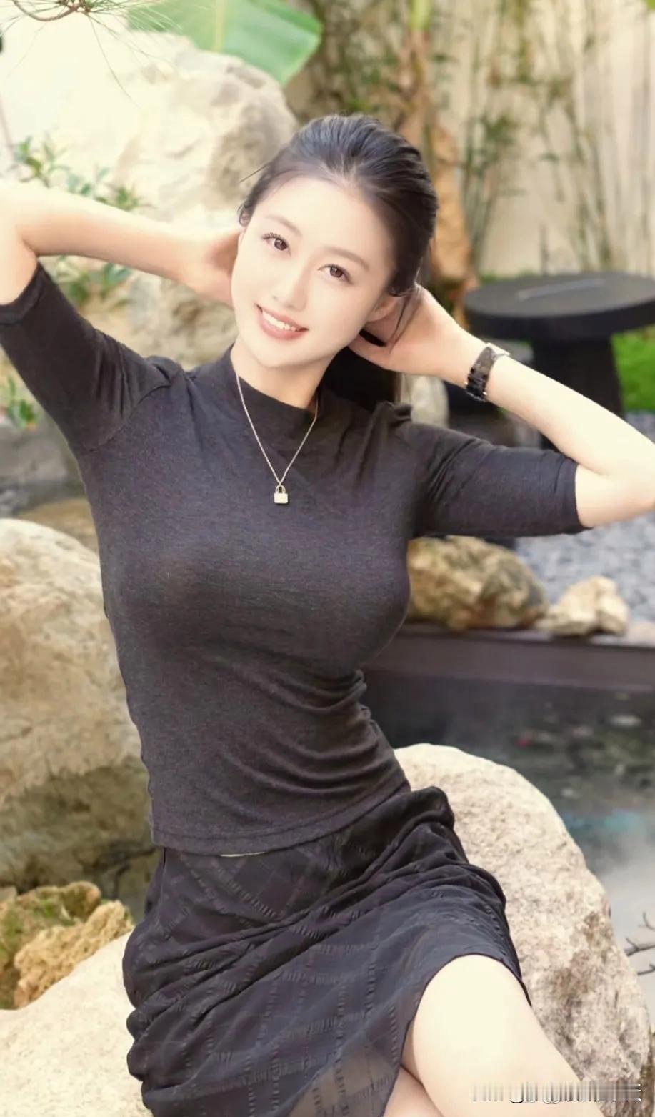 看到这位女士坐在石头上，笑容甜美，仿佛整个世界都亮了。就像千库网上那张“微笑的女