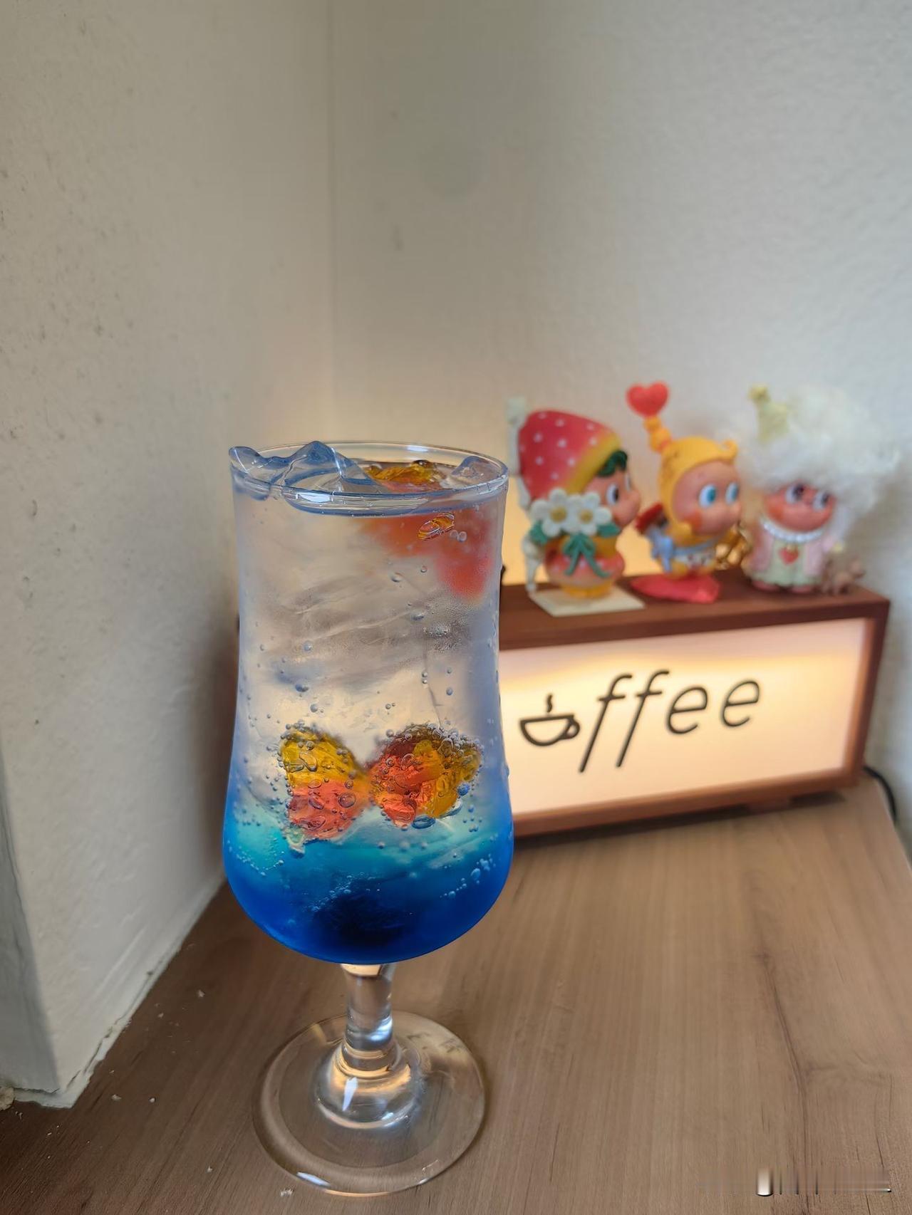 梦幻蓝橙渐变饮料，可爱小摆件相伴，咖啡馆的温馨时光。
