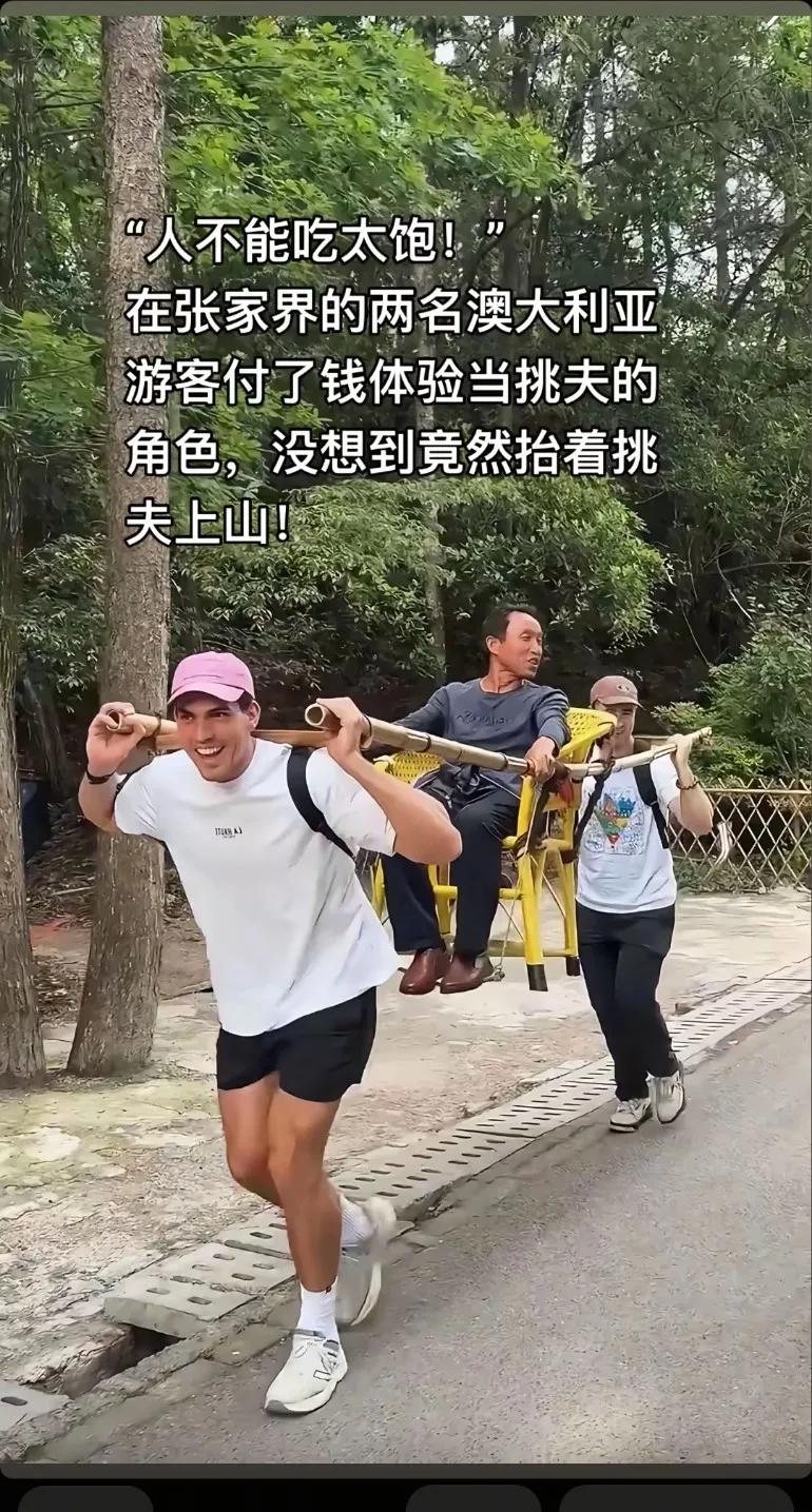 张家界两名澳大利亚游客付了钱体验当挑夫角色，没想到竟然抬着挑夫上山在老外眼里职