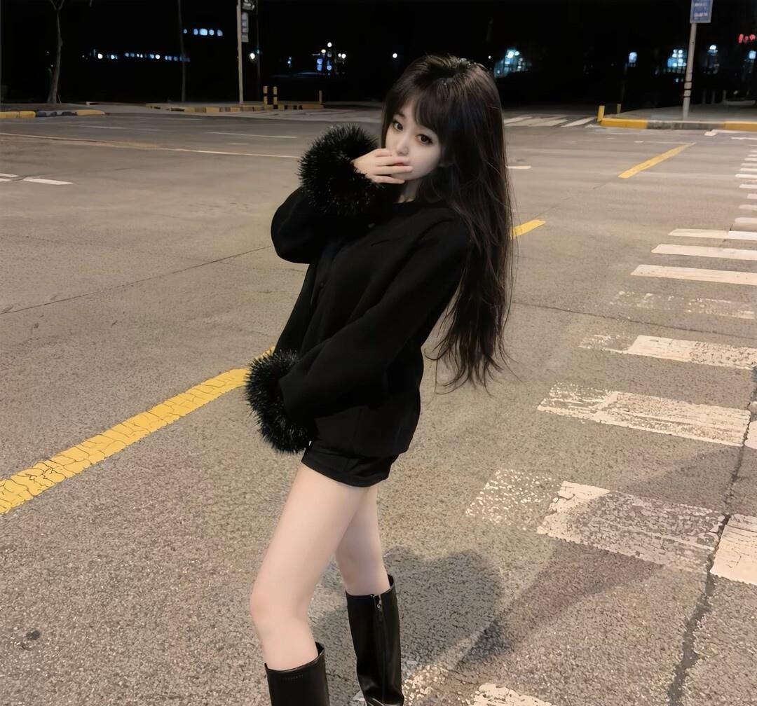 夜晚的街拍，黑色毛绒外套搭配短裤和长靴，时尚又温暖。