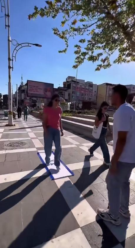 一面以色列国旗铺在伊斯坦布尔的人行道上，路过的老人、年轻人、抱孩子的妇女，几乎每