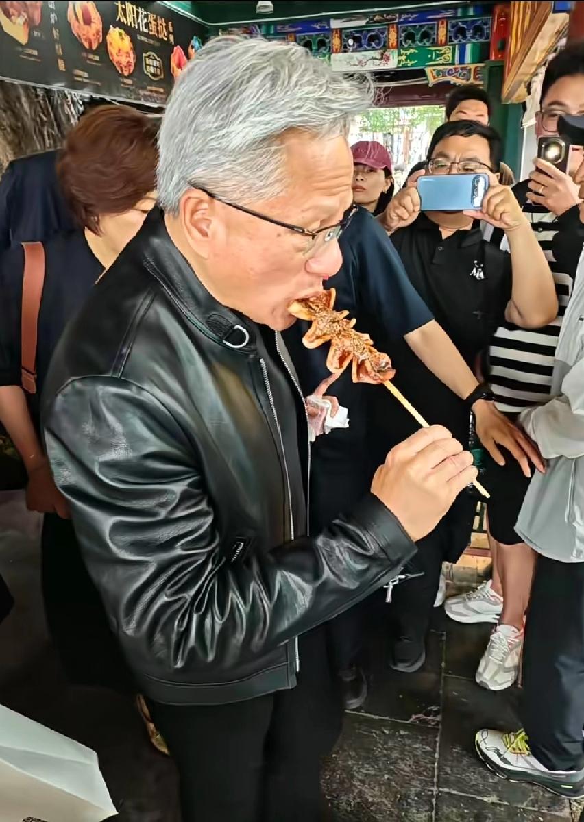 黄仁勋在北京街头撸串，烤鱿鱼，吃得那叫一个香，估计晚上宴席没吃好，清汤寡水肯定没