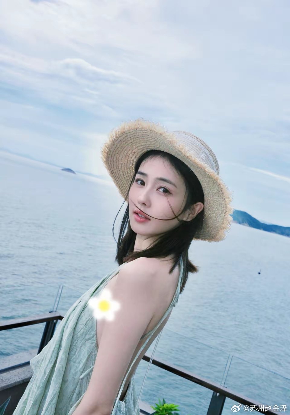 31岁白鹿分享海边度假plog，她身穿浅绿色挂脖吊带裙，头戴草帽，脸色红润，整个