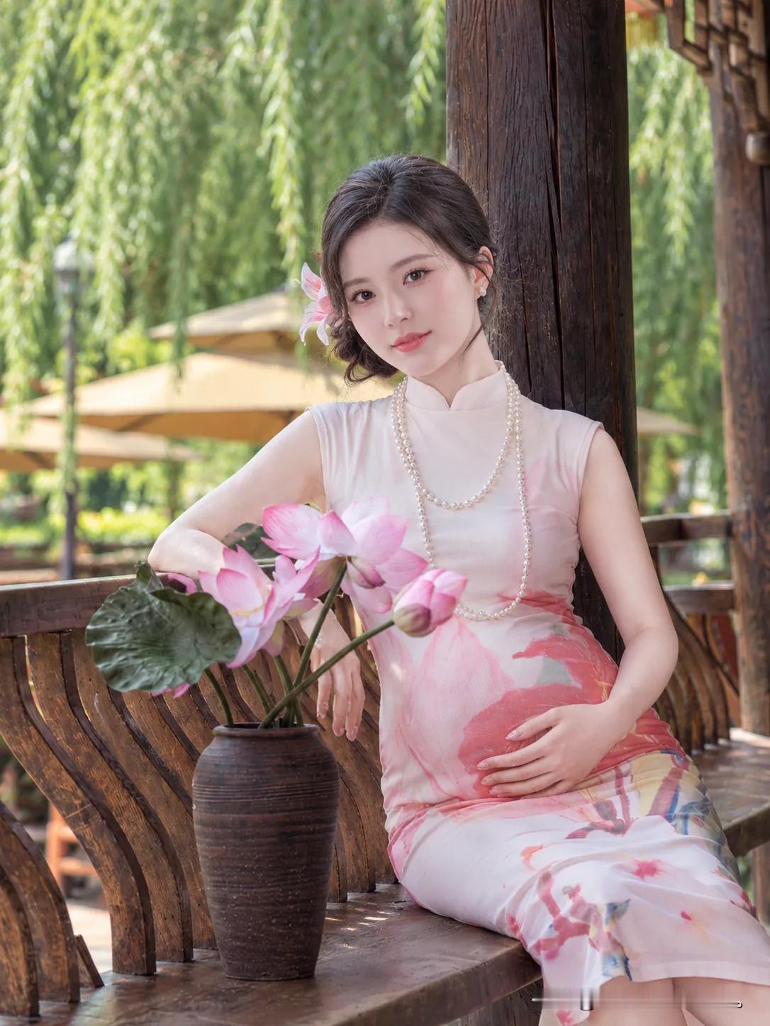 粉裙旗袍映荷花，温婉佳人倚木栏。岁月静好，这一刻的温柔与美好，只为你定格。红颜独