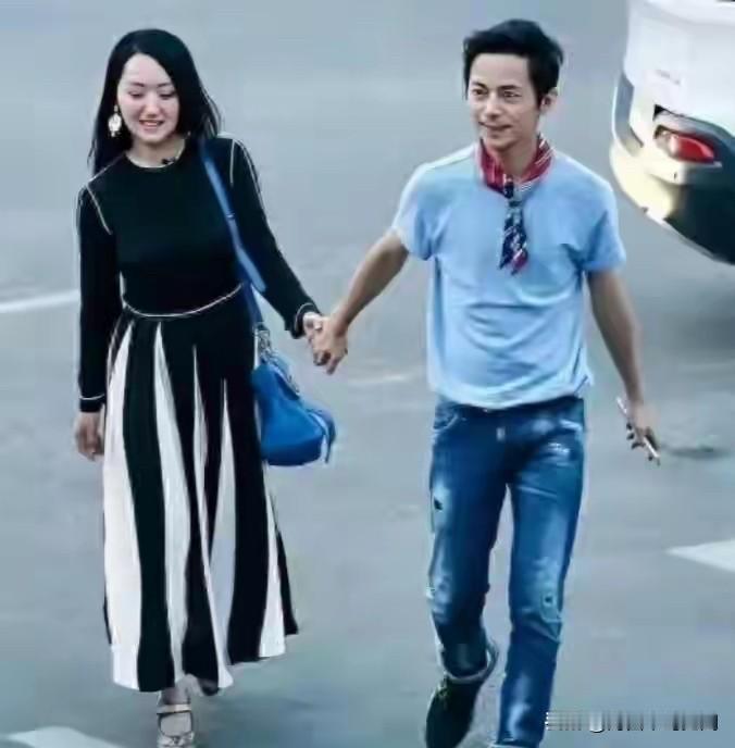 这是杨钰莹与何灵手牵手在路上的一张合影。甜歌皇后杨钰莹，嗓音清甜温润，气质温婉大