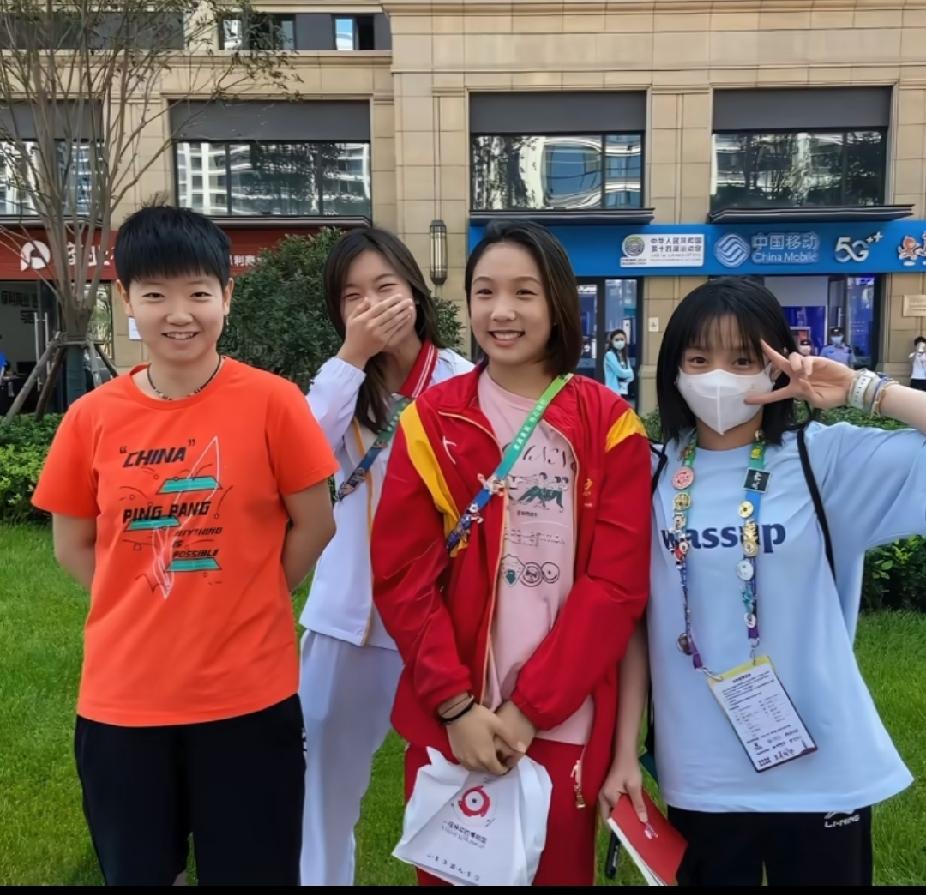 谁懂啊！这张没见过的孙颖莎也太乖了吧🥰一身亮橙色的队服，双手背在身后，乖