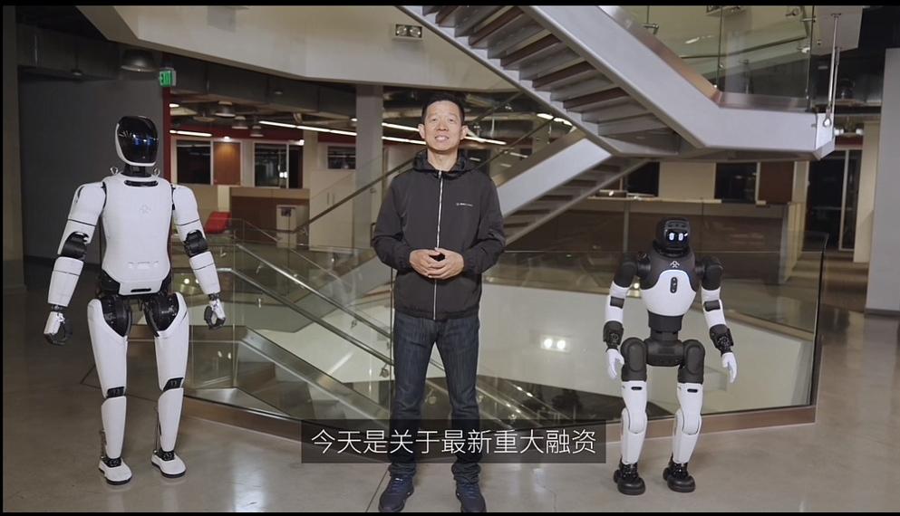 贾跃亭站在两个机器人中间，刚拿了4500万美元融资，很高兴的发布周报，又开始讲新