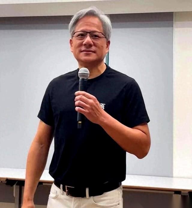 翻看英伟达掌权人黄仁勋的公开照片，有一幕极具视觉冲击力。老黄穿着那件半永久的黑皮