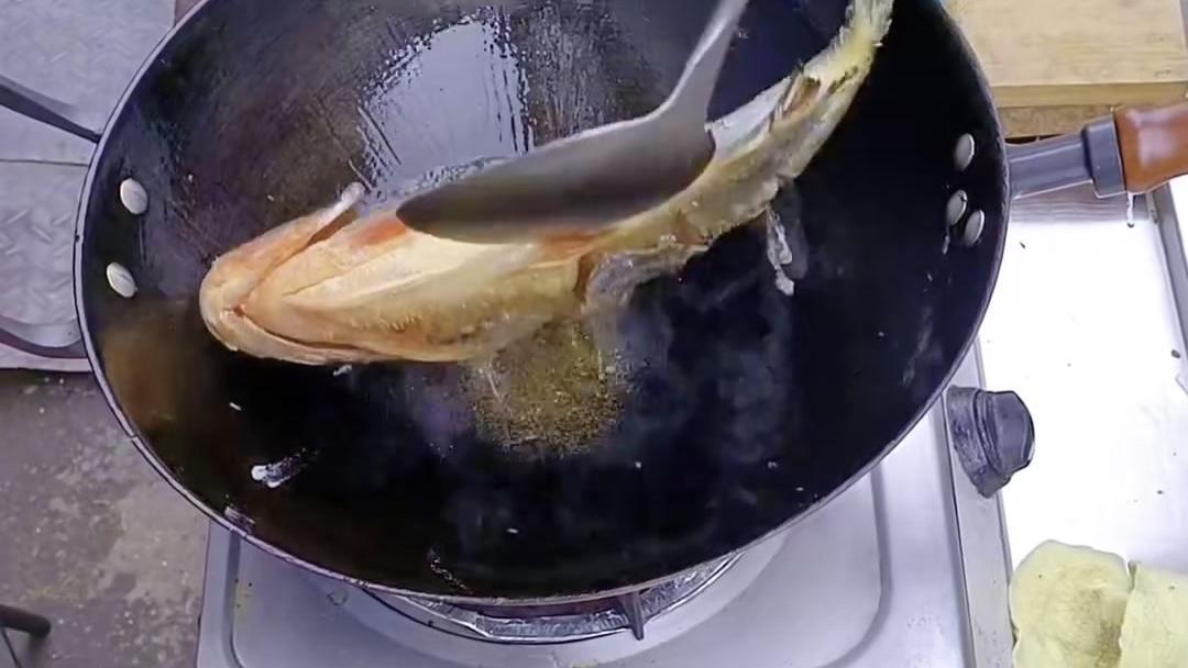 男子用铁锅煎鱼，翻到另一面鱼自己又翻过来，鱼：这边太疼了 还是那边吧