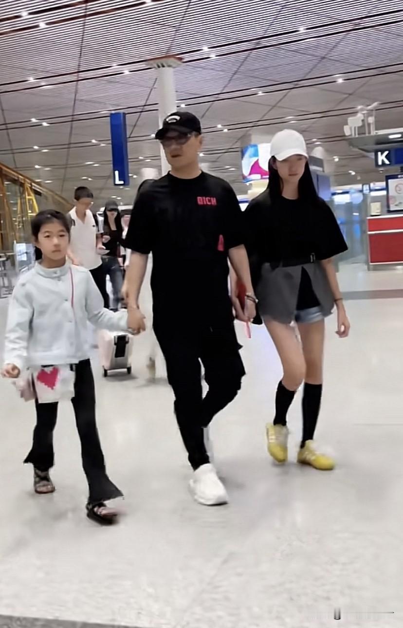 汪峰这次带着四个孩子走机场，一手牵着醒醒和二女儿，大女儿独自拉行李箱跟在后面，继