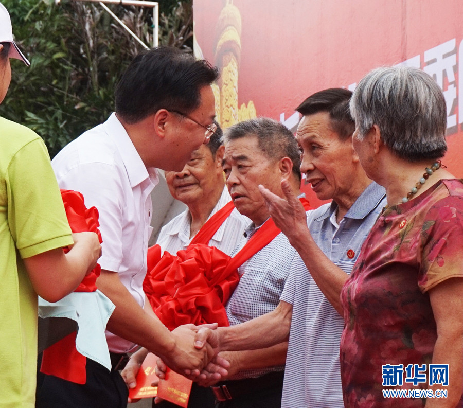 广州市天河区委常委,组织部部长龚伟河为老党员佩戴红花,颁发慰问金.