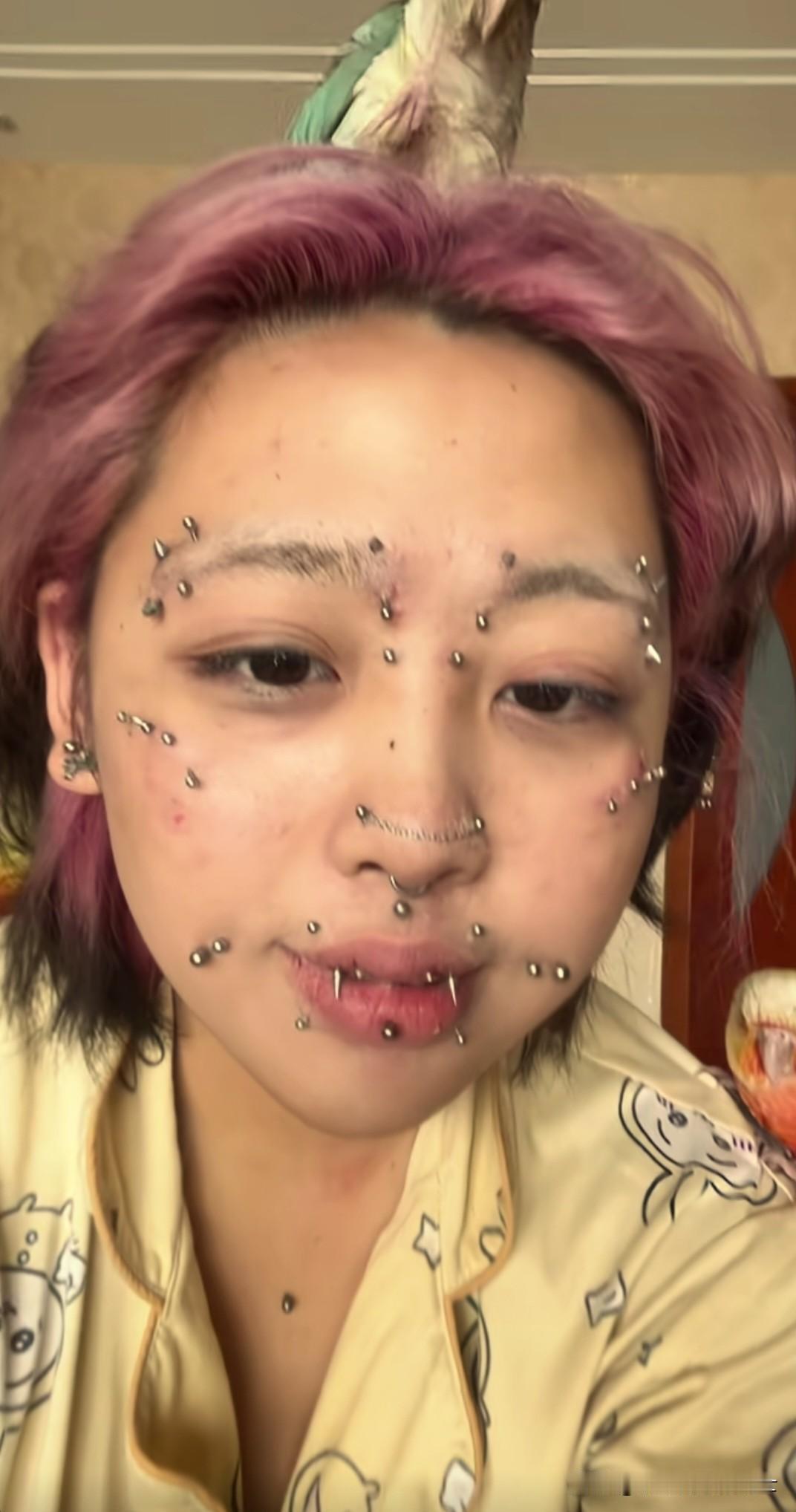 今天刷视频时，看到一个脸上打满钉子的女孩。这个女孩染着红色的头发，戴着鼻环，