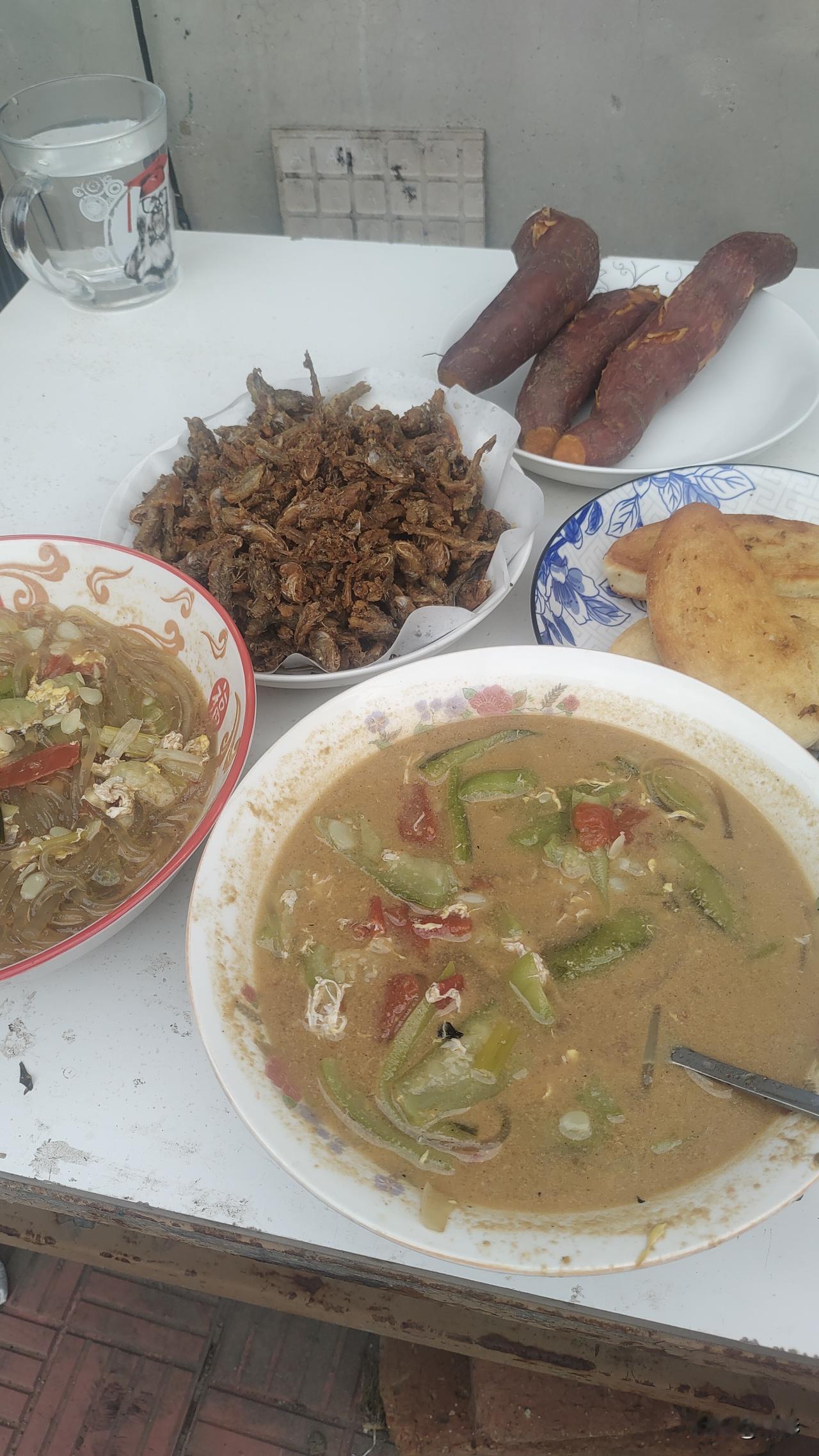 今天早上的早餐是丝瓜汤和油炸狗杠鱼，主食是油煎馒头片加蒸地瓜。我拿了一小块狗杠
