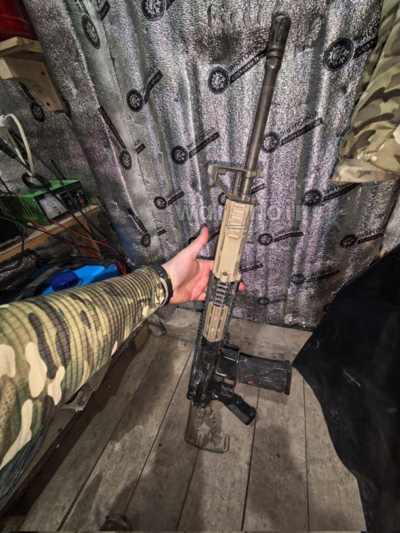 一名俄罗斯武装部队战士展示他从一名乌克兰士兵手中缴获的武器。这名俄罗斯战士缴