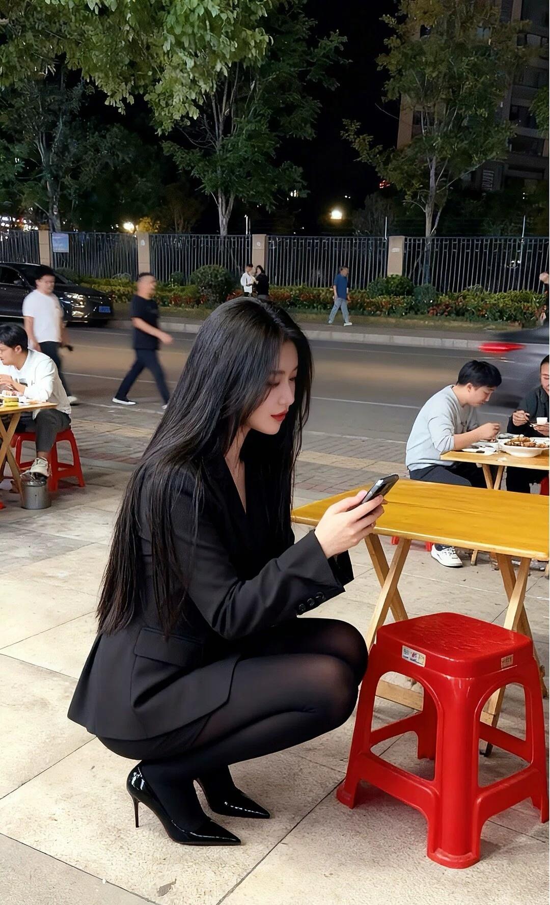 都市夜色下的时尚蹲姿，手机里的世界与现实交错。