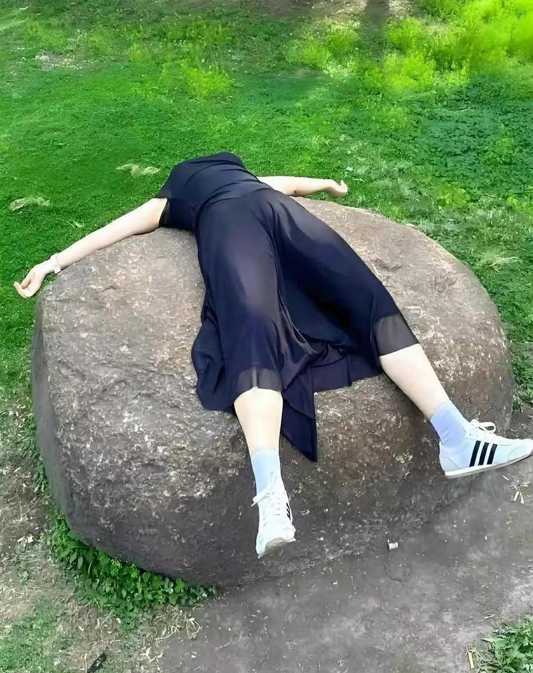 和女同事在公园闲逛，没多会儿就钻进了小树林。然后她突然往大石头上一躺，直说累得够