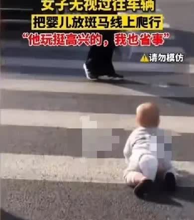 一个女人带娃，居然把婴儿放在斑马线上玩，婴儿在斑马线上爬来爬去，四周车辆刷刷的过