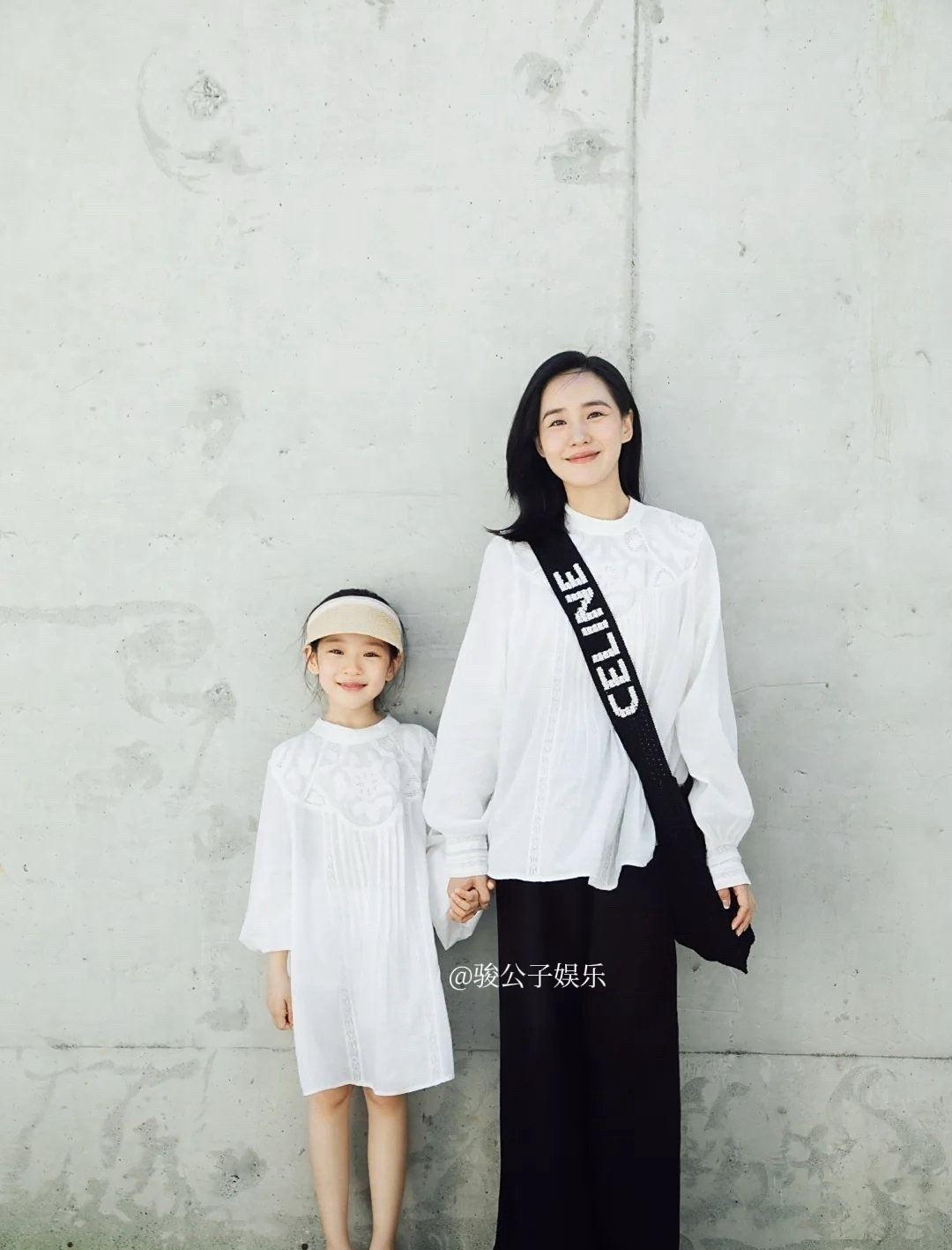 王智与女儿一同出游，母女俩穿着同款套头衬衫，十分时尚。女儿长相酷似妈妈，从小就是