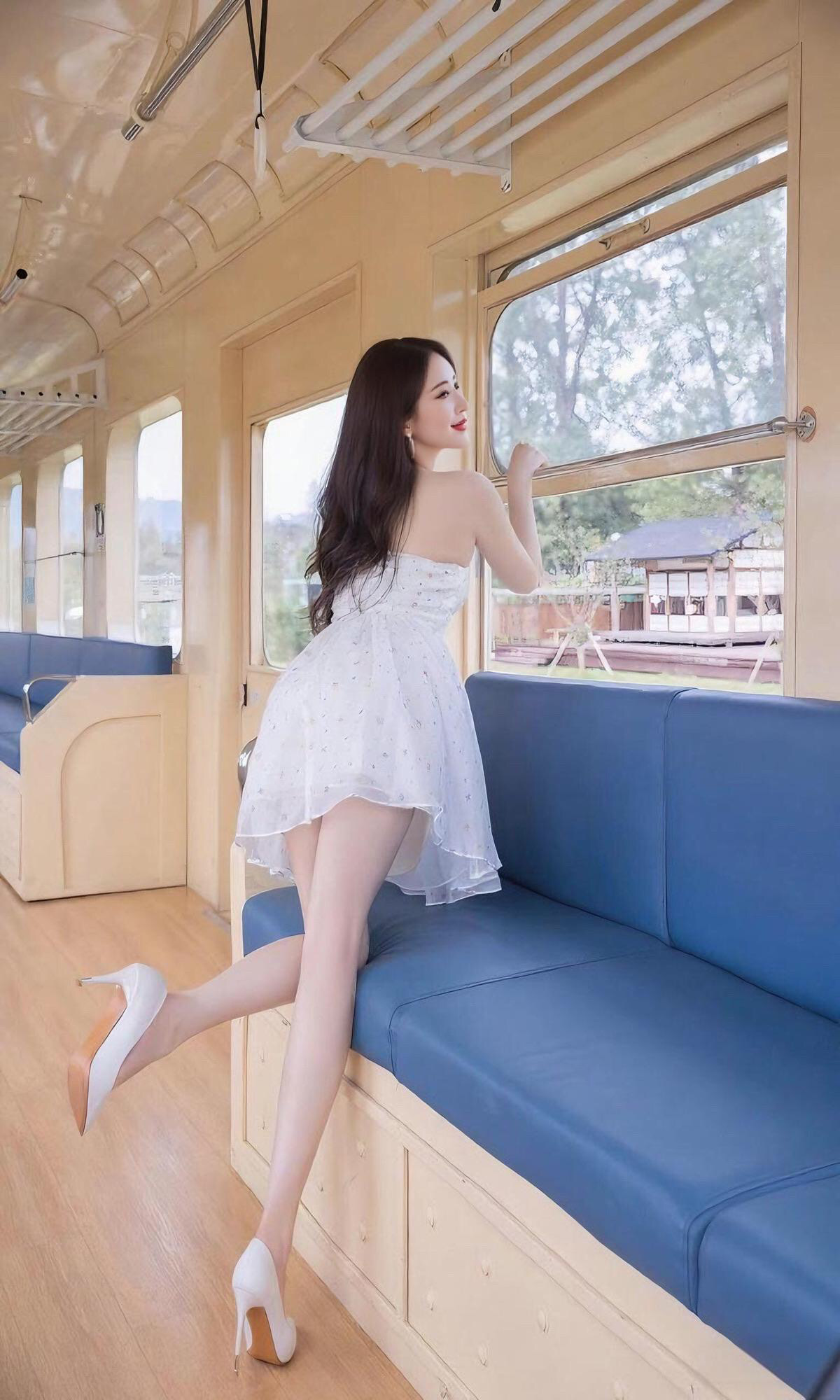 她倚着车窗，目光追随着远方的风景，恬静而美好。”