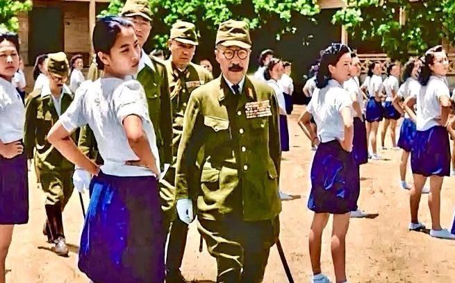 他戴着黑框眼镜，穿着军装，腰间挂着指挥刀，脚蹬皮靴，在几个随从的簇拥下，趾高气扬