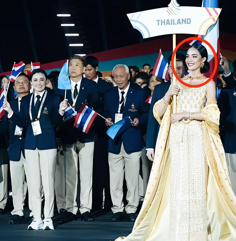 礼仪小姐都被泰国王后苏提达给吸引了吗？这斜视的眼神，一直在盯着看啊！手里举着
