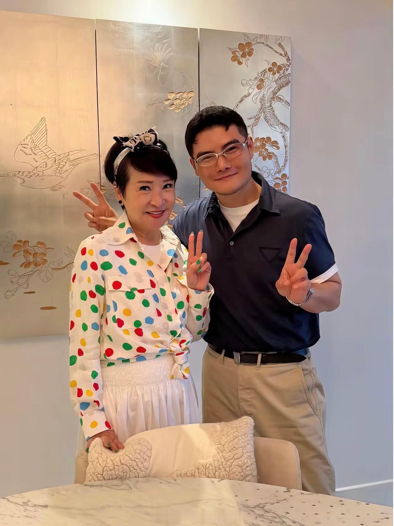 75岁狄波拉和一名年轻男子聚会，她的状态真好，戴着蝴蝶结发箍，穿衣打扮时尚，整个