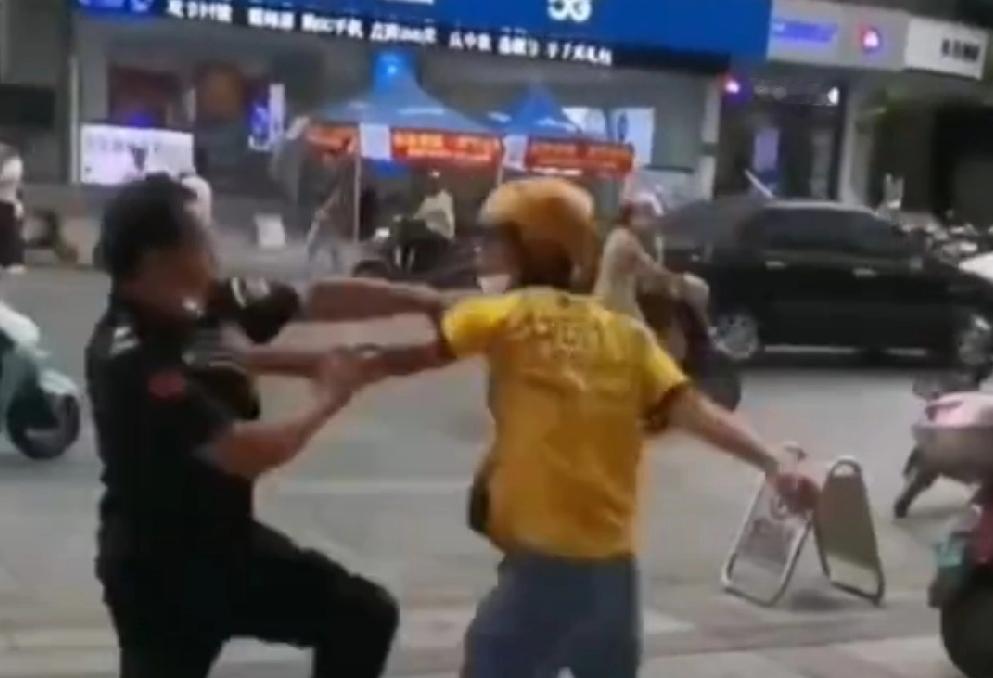 底层人为何总爱为难底层人？某小区门口，外卖骑手小陈将电动车停在步道边，跨过护