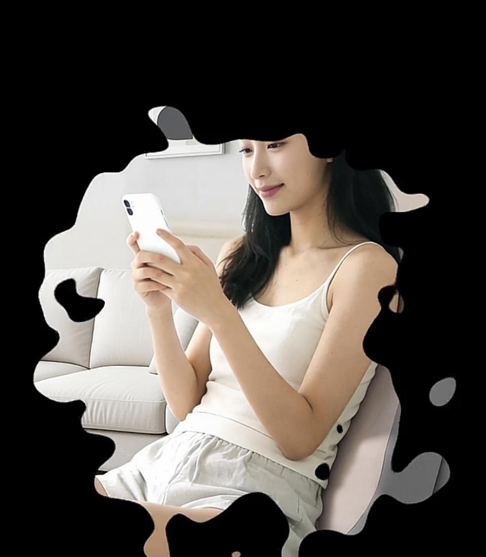 女孩坐在沙发上，专注看手机。