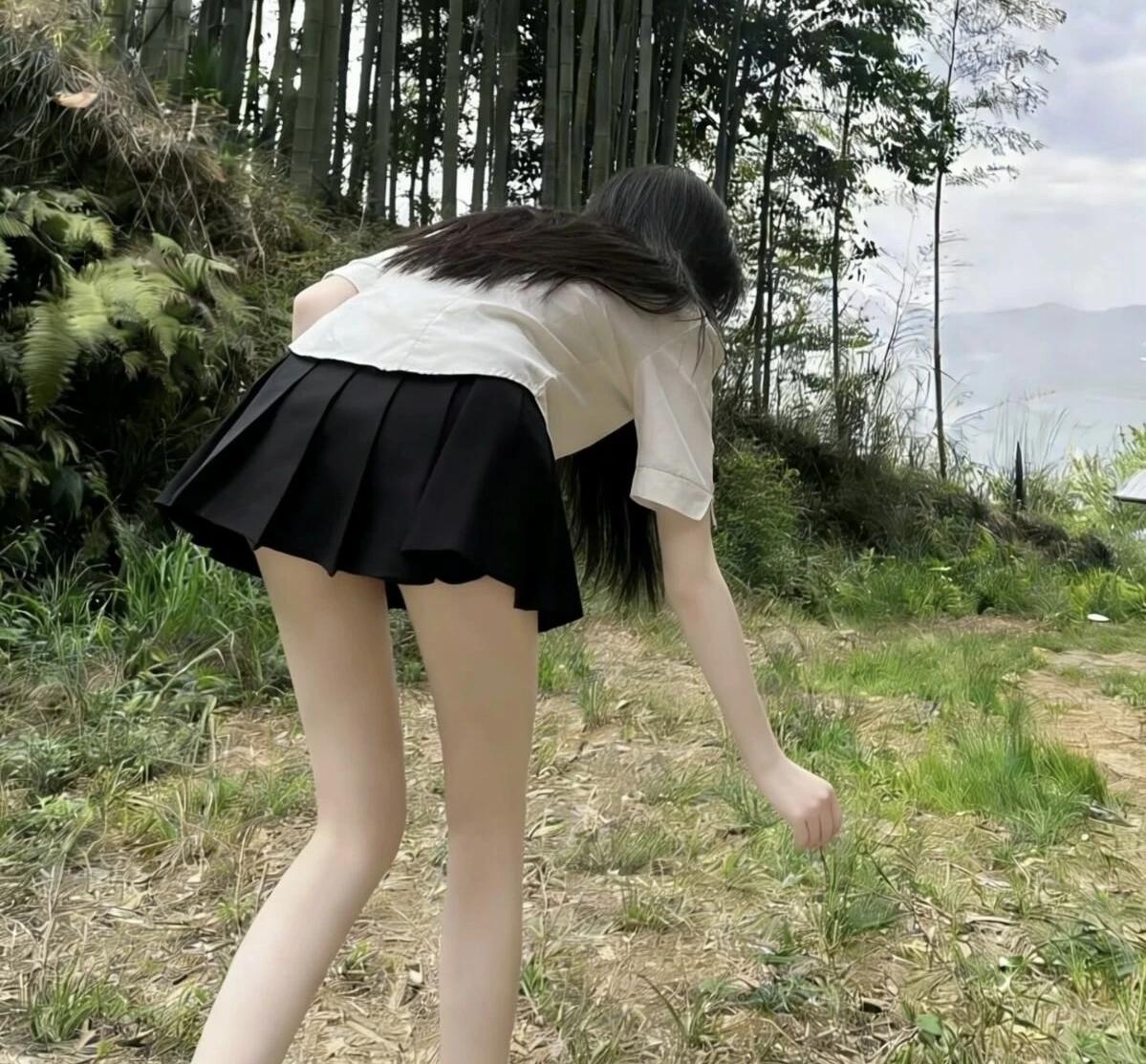 少女在竹林间弯腰，裙摆随风飘扬，自然与青春的完美结合。