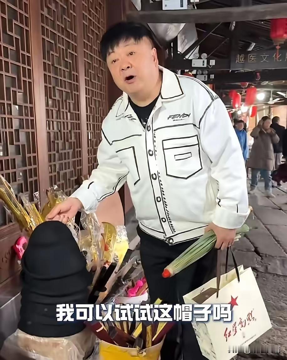 洪剑涛在浙江绍兴安昌古镇逛街时，看中了一个帽子想试戴一下，老板却说：“试一下5块