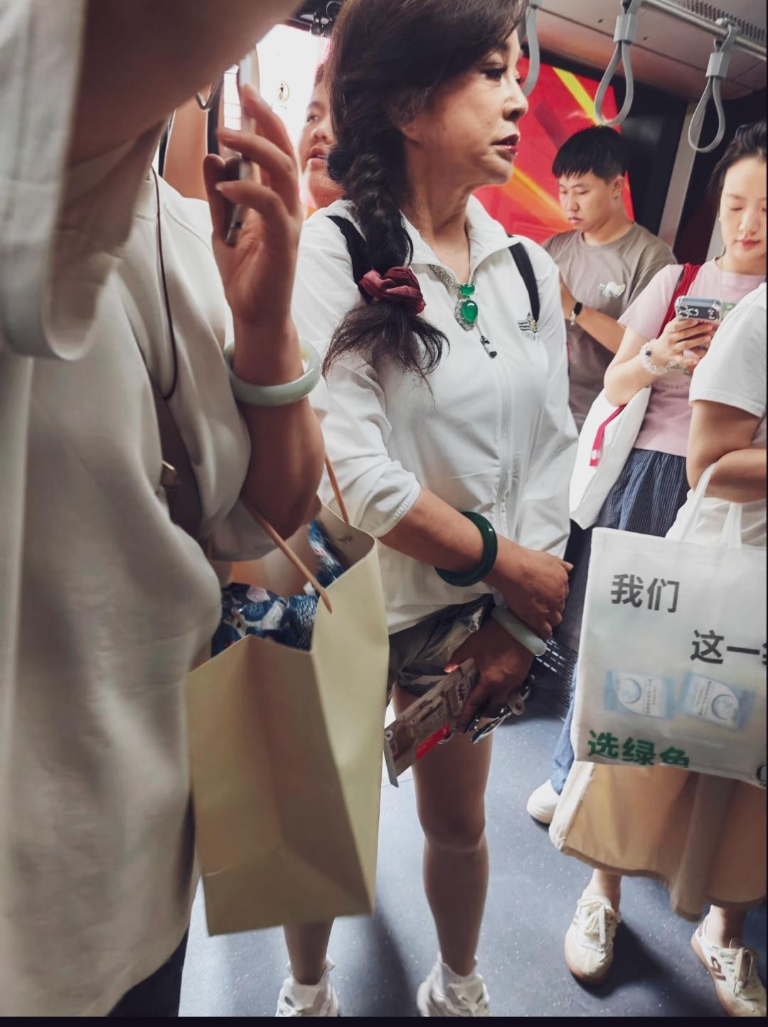 刘晓庆机场搭乘摆渡车，白色轻薄外套配迷彩短裤+白色运动鞋。长发编成粗麻花辫，用酒