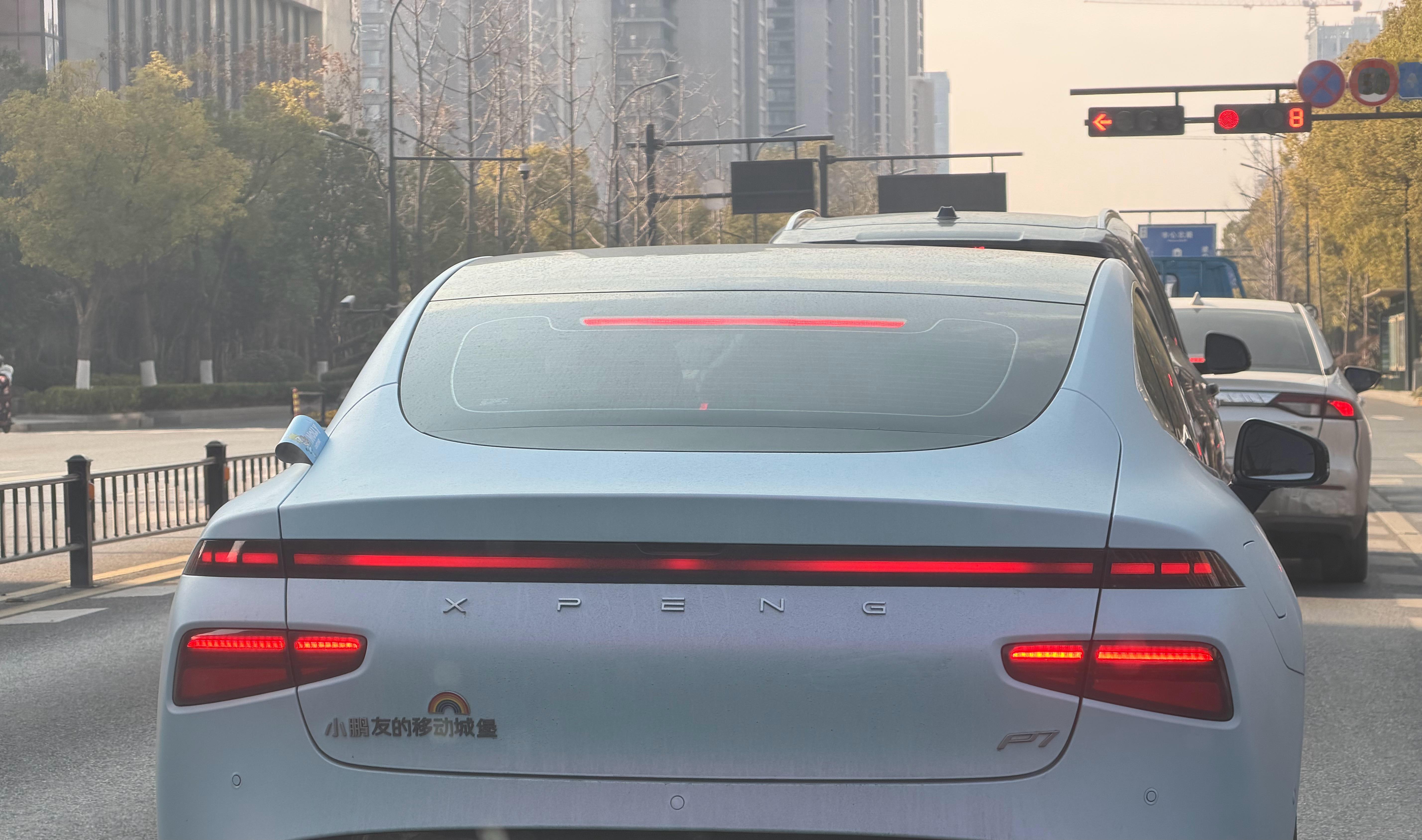 等红灯时被前面的小鹏P7戳中笑点！车尾贴的“小鹏友的移动城堡”也太会玩了，这波D