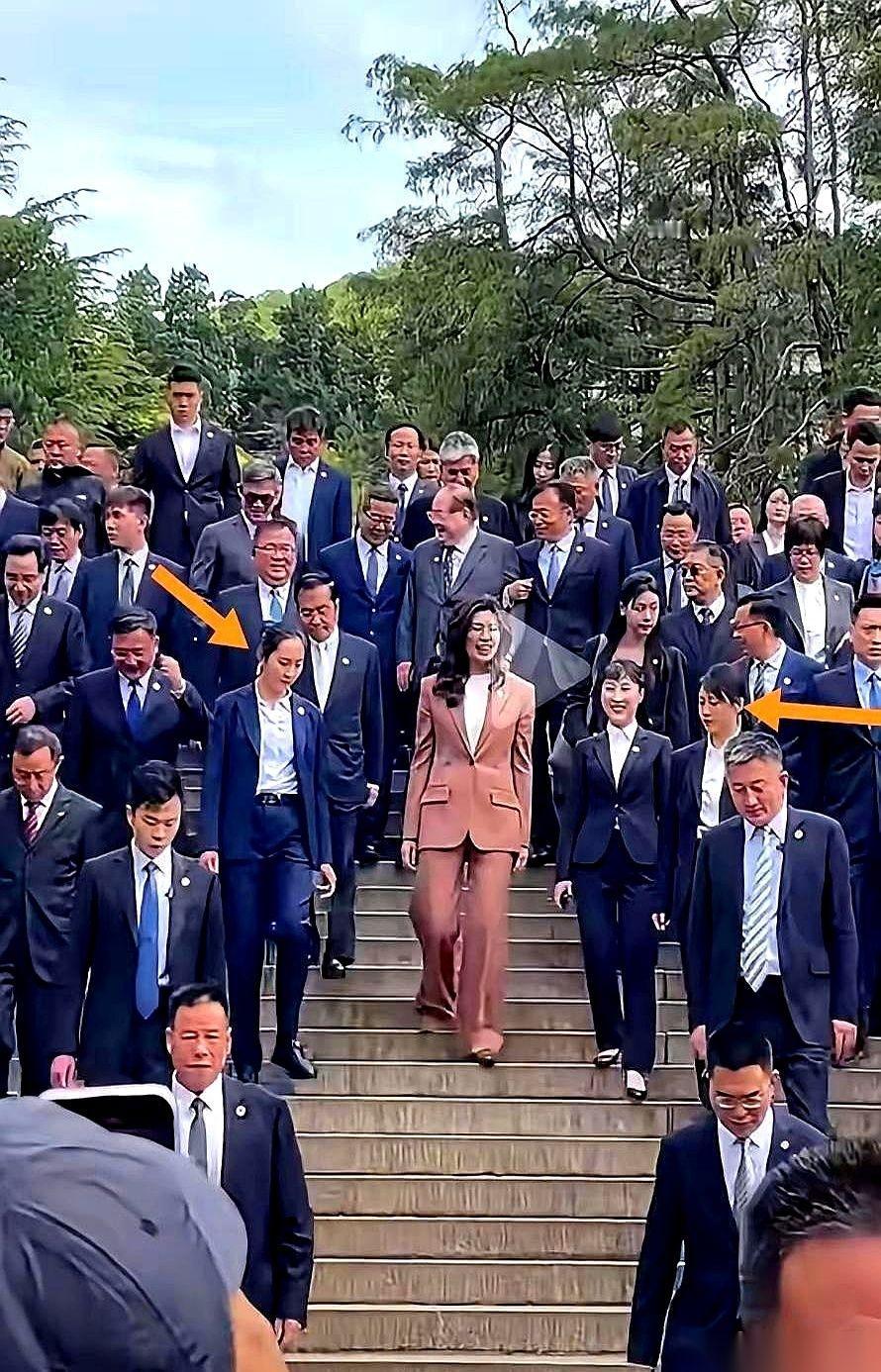 两边各站一个女保镖，黑西装，戴耳麦，步子迈得跟一个人似的。很多人觉得，这排场够
