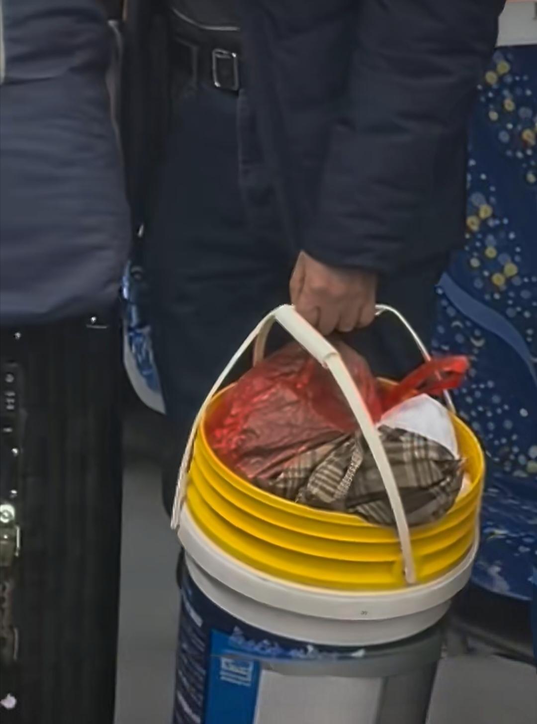 54岁农民工返乡，手里的塑料桶格外显眼，装的是一整年的牵挂！在长沙城铁站，