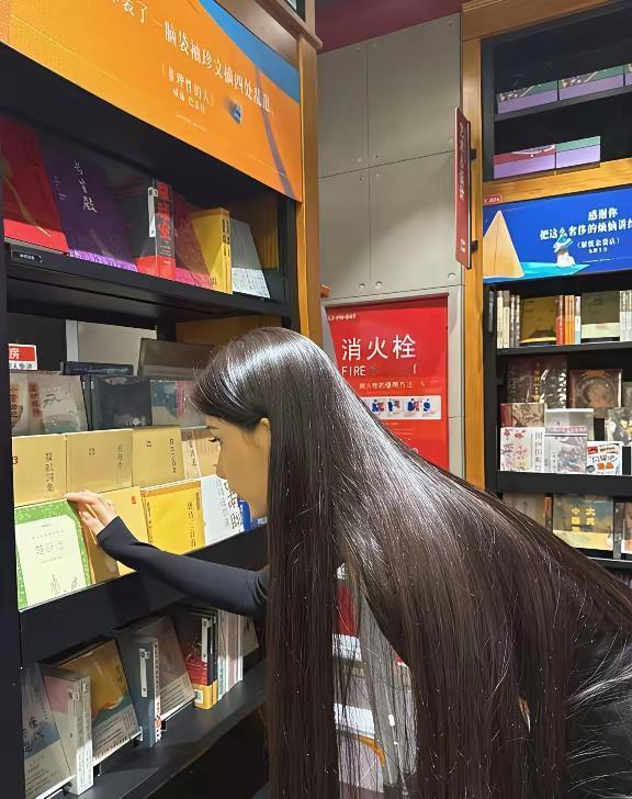 一位长发女士在书店认真挑选书籍。书香气质女孩书店百态﻿﻿