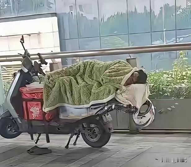 跑单王裹被子睡在电动车上，早上上班在路边，我老看见个外卖小哥，裹着厚被子在电动车