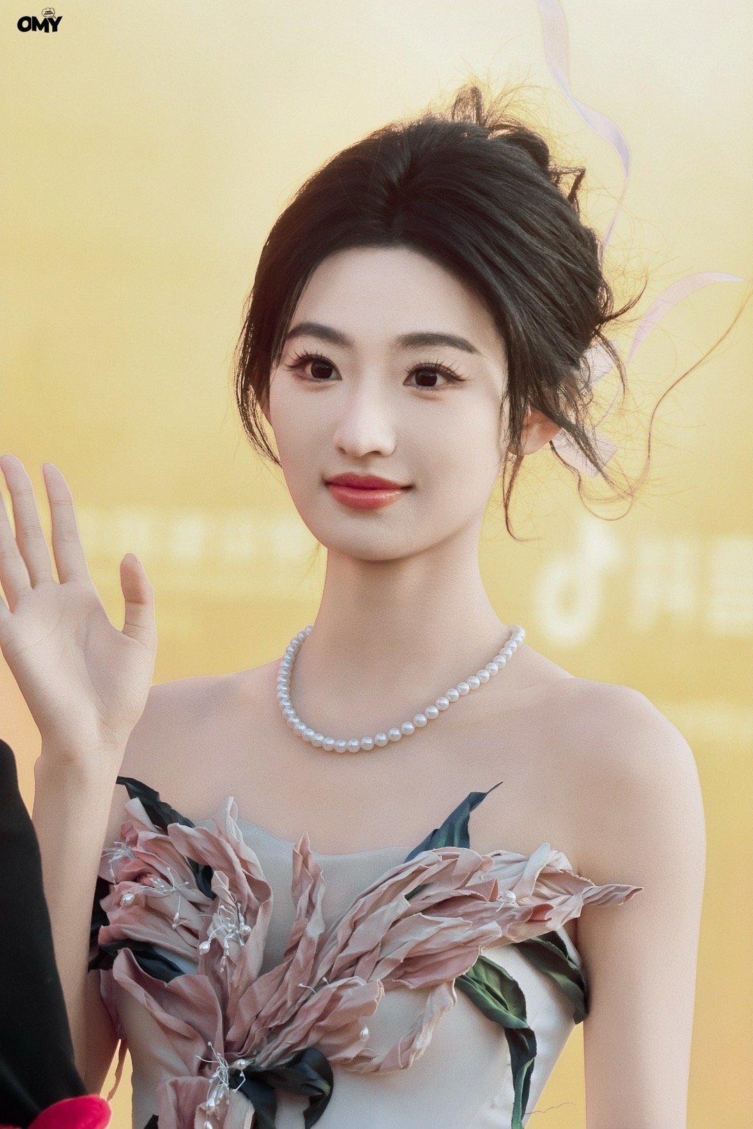 杨雨潼一袭缀着粉花的白裙，在光影里温柔得像带着香气的晚风，优雅又明媚。