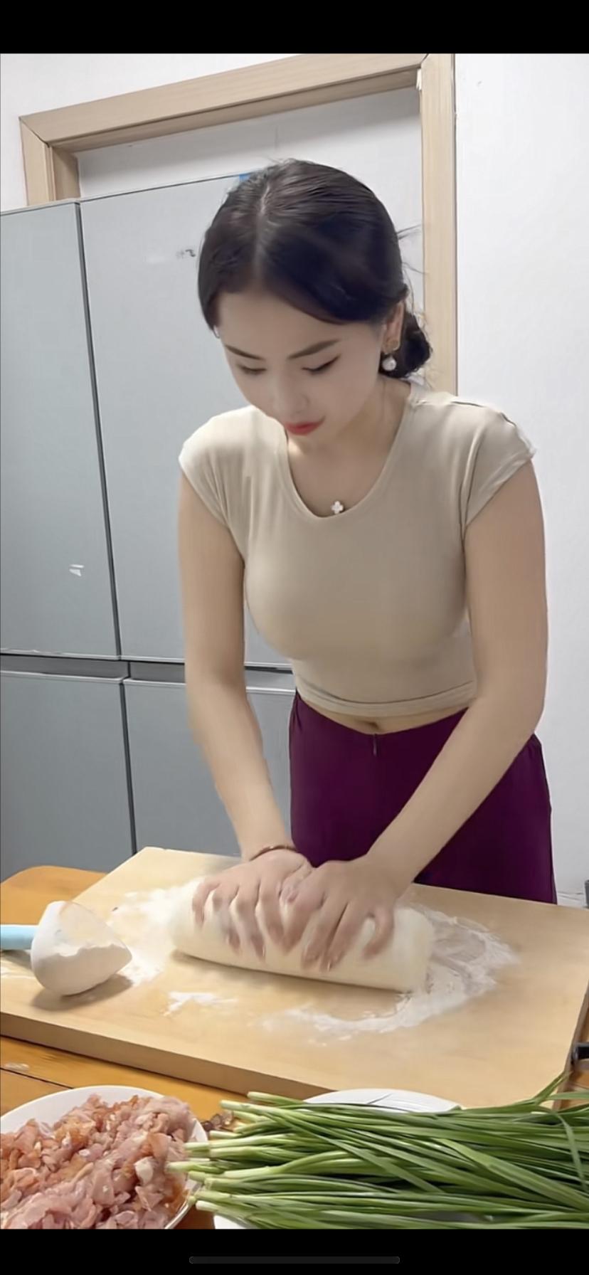 妹子正在擀面皮准备包饺子。